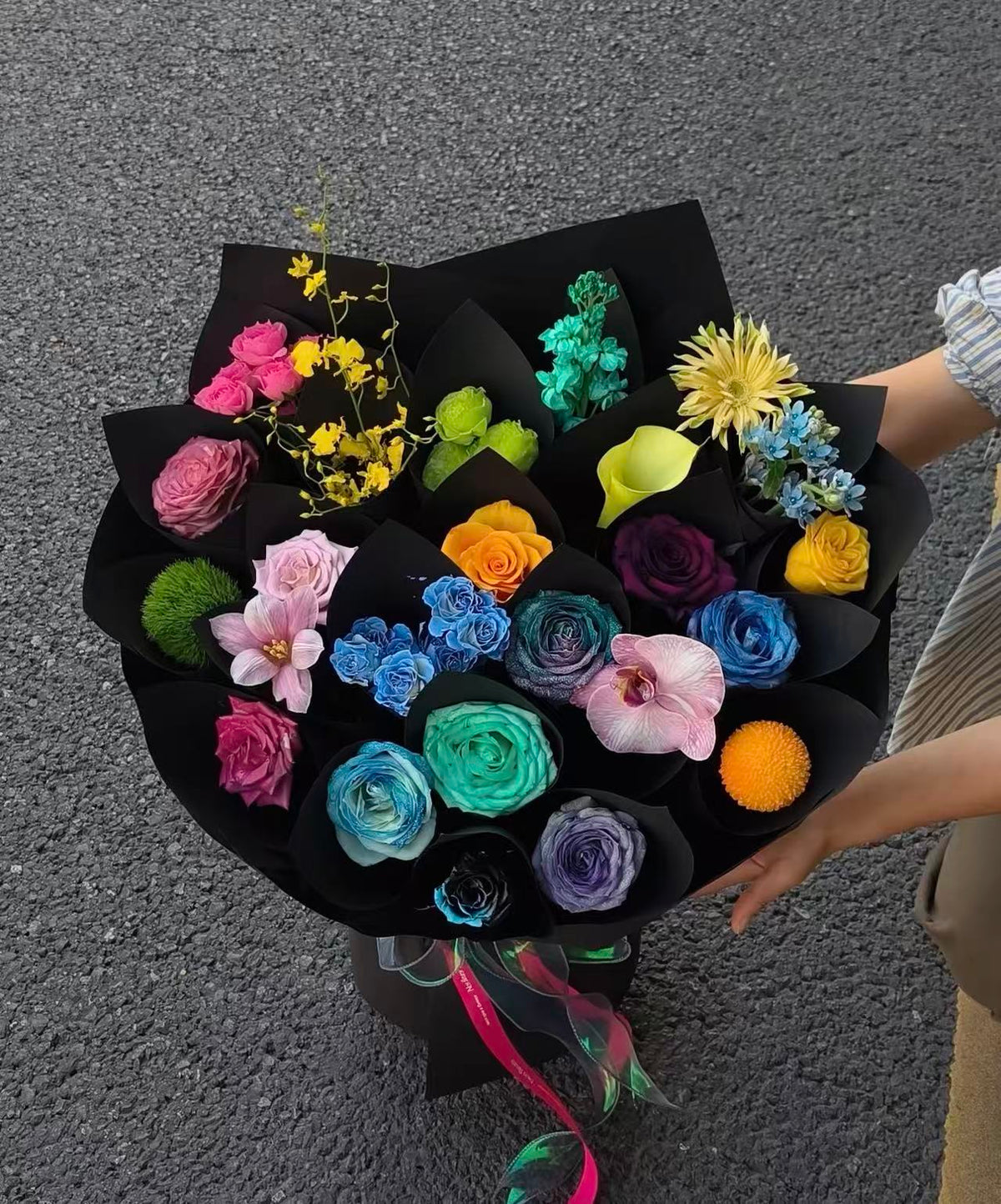 Colorful preserved bouquet in black wrapping