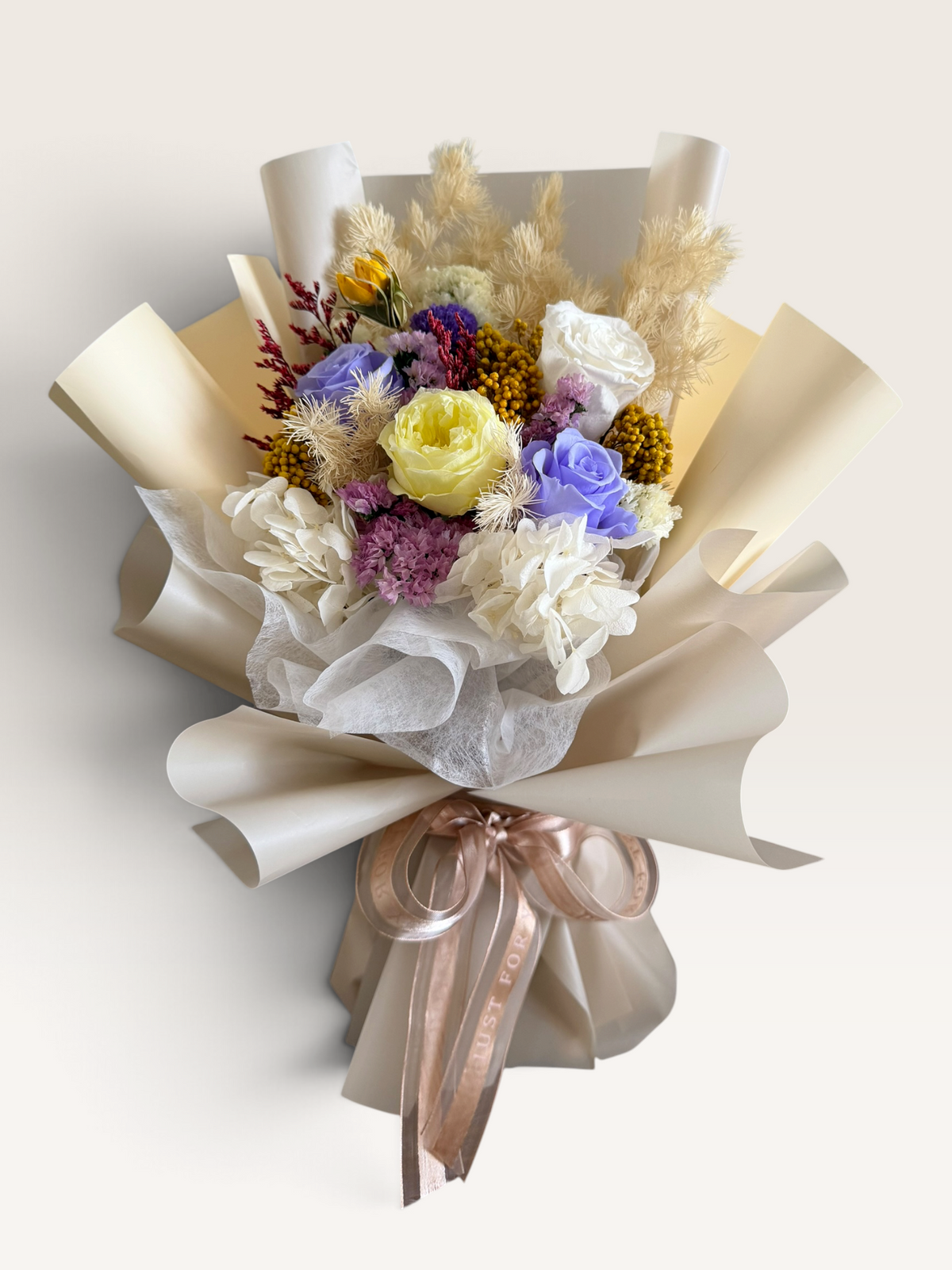 French Vanilla preserved bouquet with lavender, ivory and pale yellow roses, cream wrapping and champagne ribbon