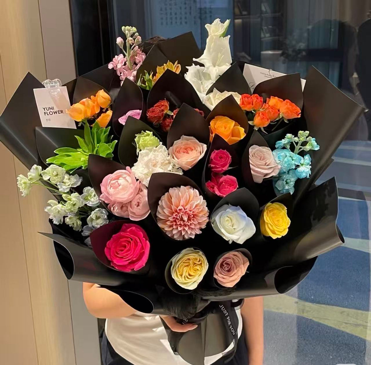 Bold preserved rose bouquet arranged in black wrapping
